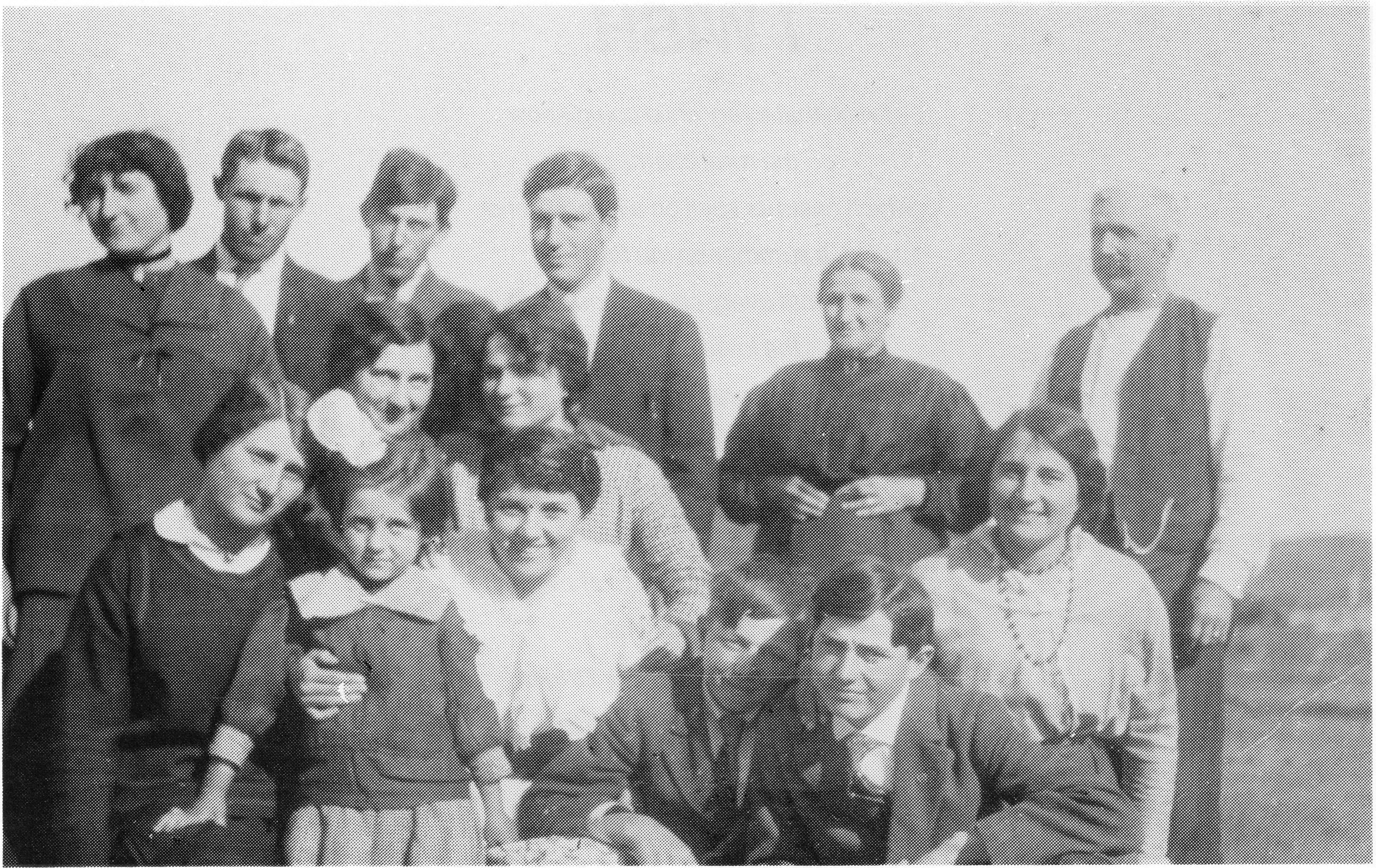 Group photograph of a family gathering outdoors. Several adults and children are posed together.
