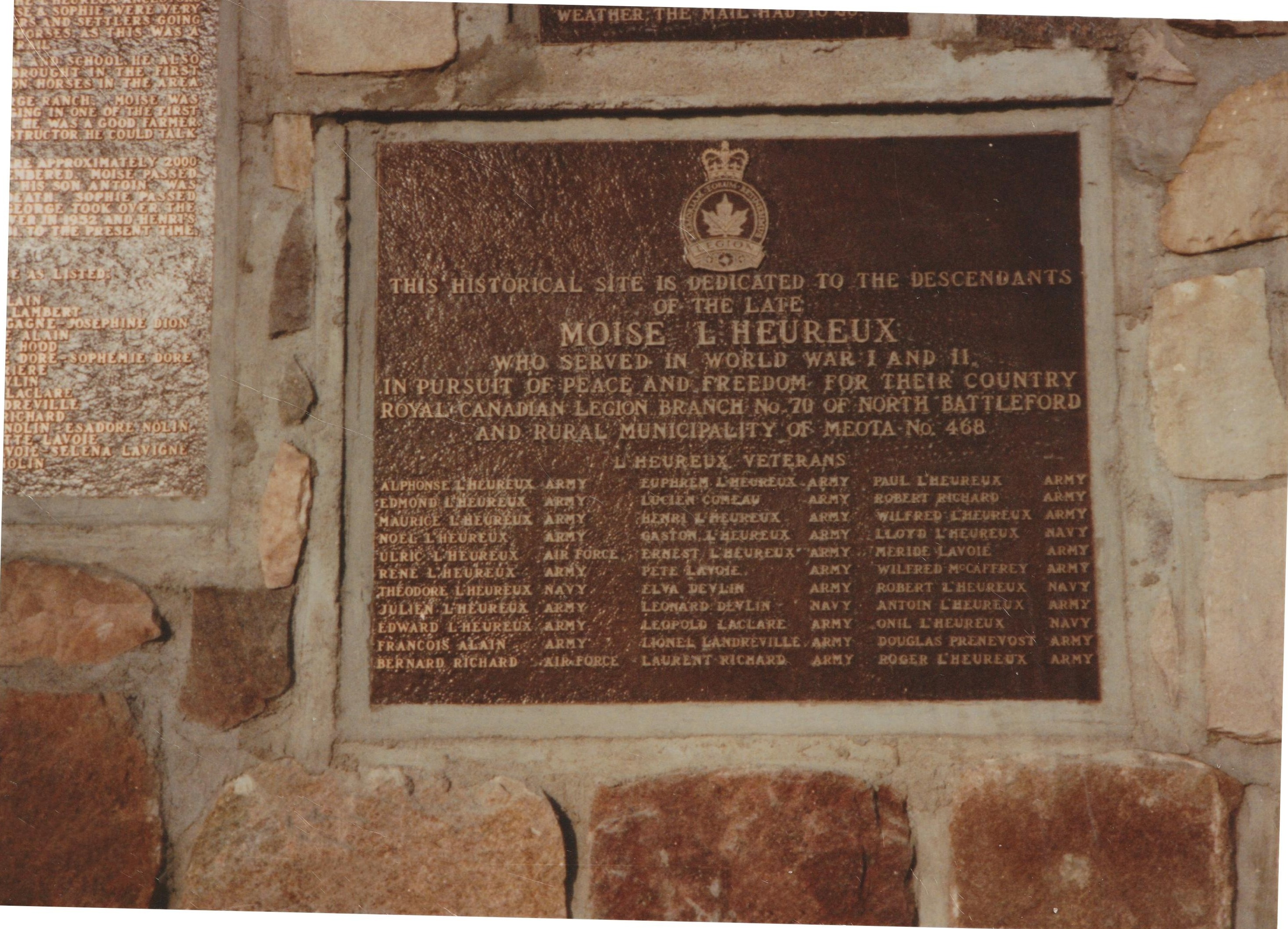 Two bronze plaques mounted on a stone wall.